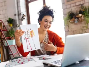 illustratrice che mostra un disegno a un cliente in videochiamata